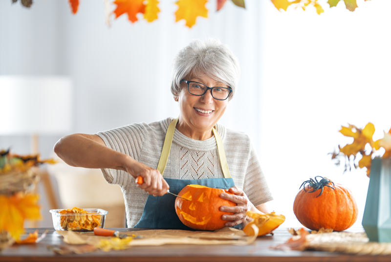 Senior carving Halloween pumpkin at retirement community in Maple Ridge