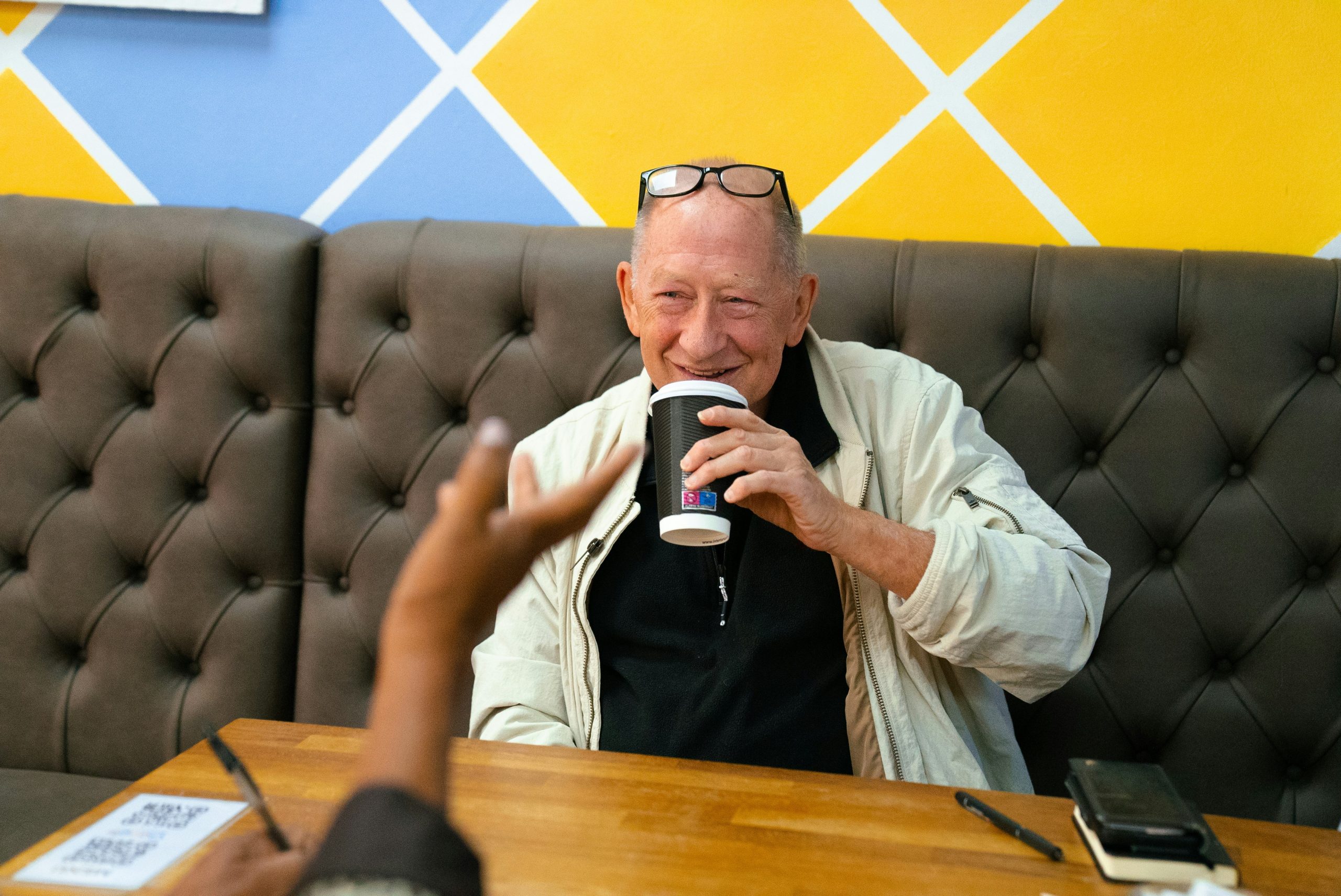 a senior man sipping on a coffee smiling
