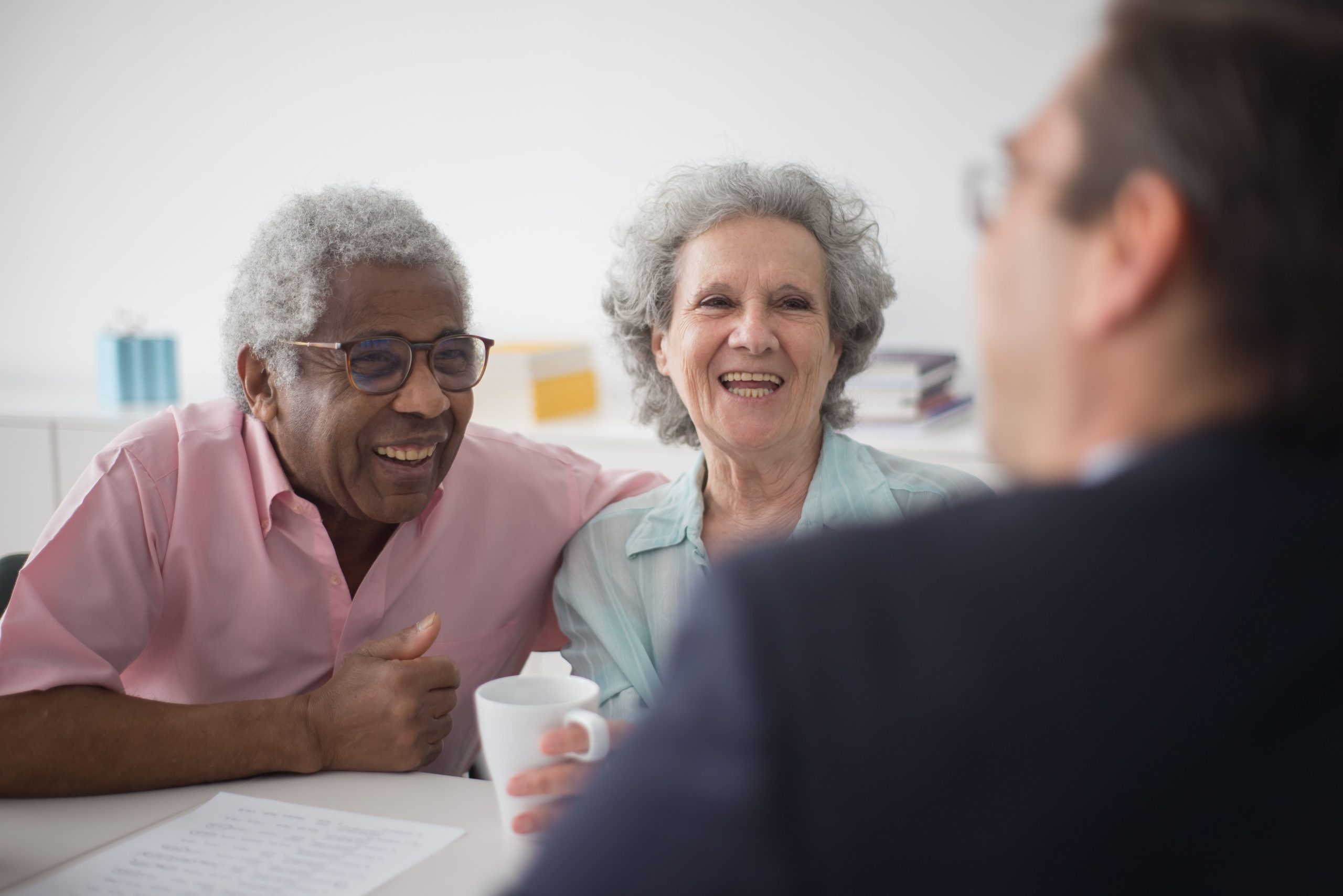 two seniors laughing while talking to staff